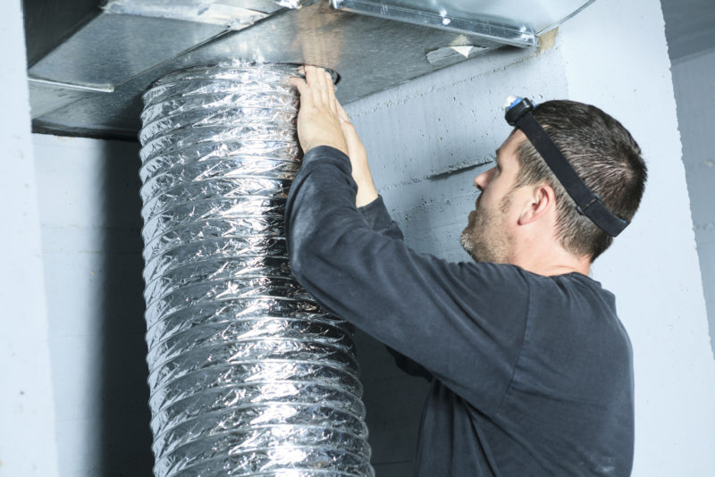 Technician servicing air ducts.