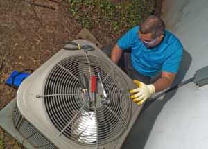 Overhead view of technician servicing outdoor AC unit.